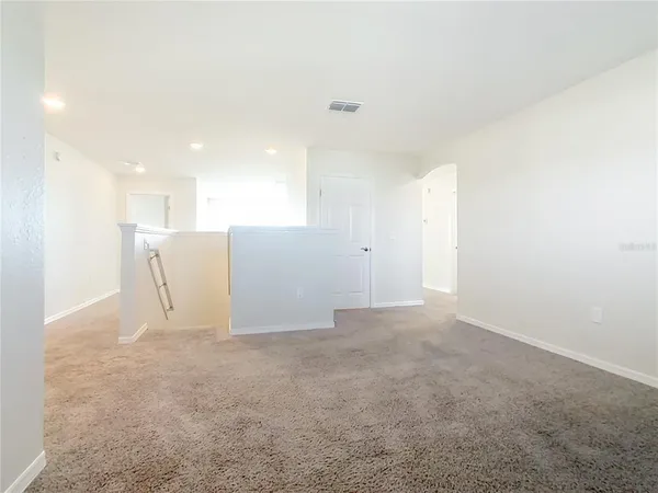 an empty room with a window and a ceiling fan