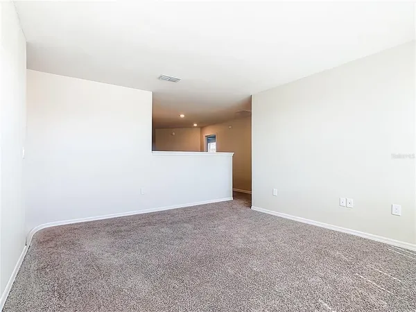 an empty room with a window and a ceiling fan