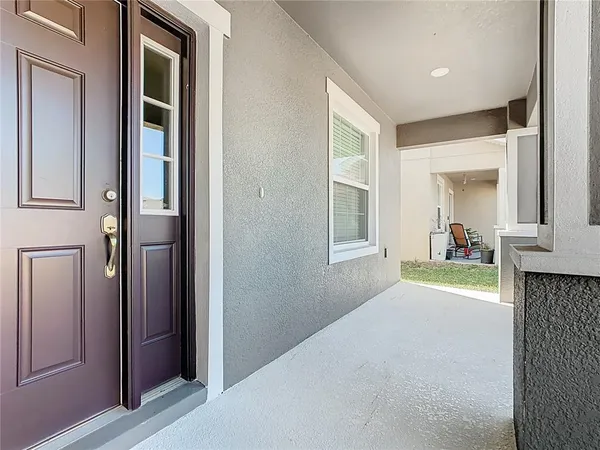 an empty room with wooden floor chandelier fan and windows