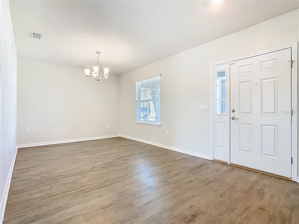 an empty room with wooden floor and a ceiling fan