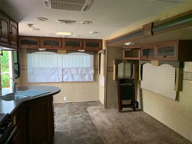 a kitchen with stainless steel appliances granite countertop a refrigerator a sink a stove a washer and dryer