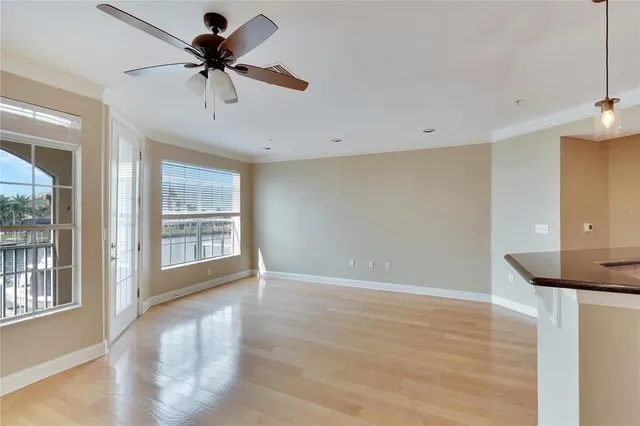 a view of a big room with wooden floor and a ceiling fan