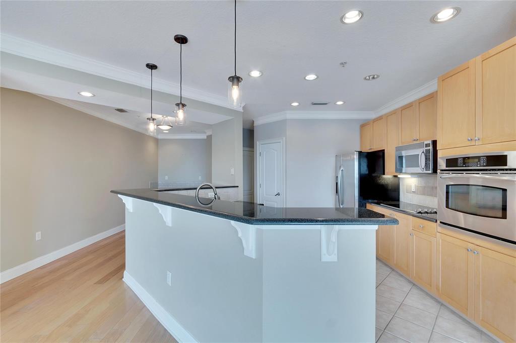 6414 Sunset Bay Circle Apollo Beach, FL 33572 - Photo 20 of 50 a large kitchen with stainless steel appliances a large counter top a stove and a sink