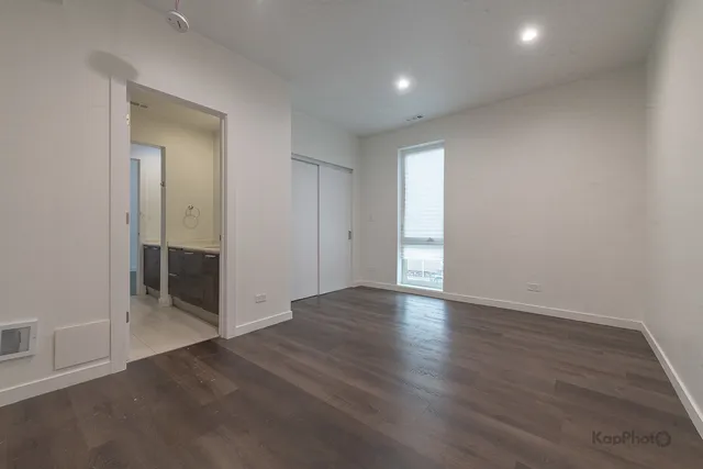 an empty room with wooden floor and mirror