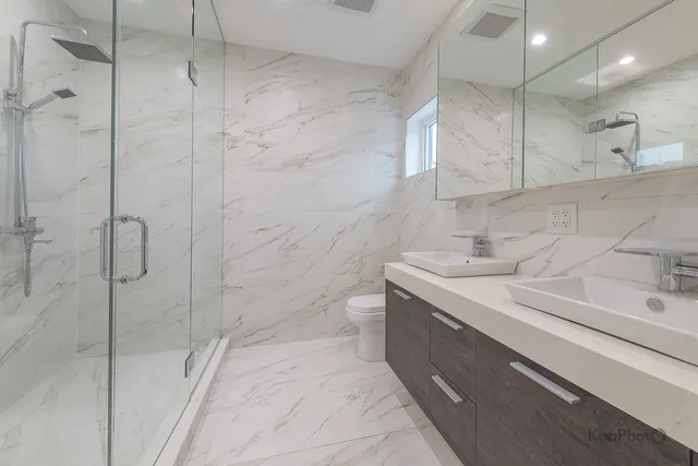 a bathroom with a sink a toilet and shower