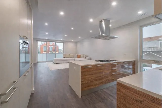 a view of a kitchen center island and stainless steel appliances