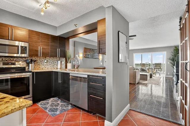 a kitchen with stainless steel appliances kitchen island granite countertop a refrigerator and a stove top oven