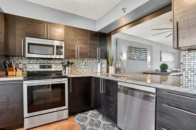 a kitchen with stainless steel appliances kitchen island granite countertop a stove sink and microwave
