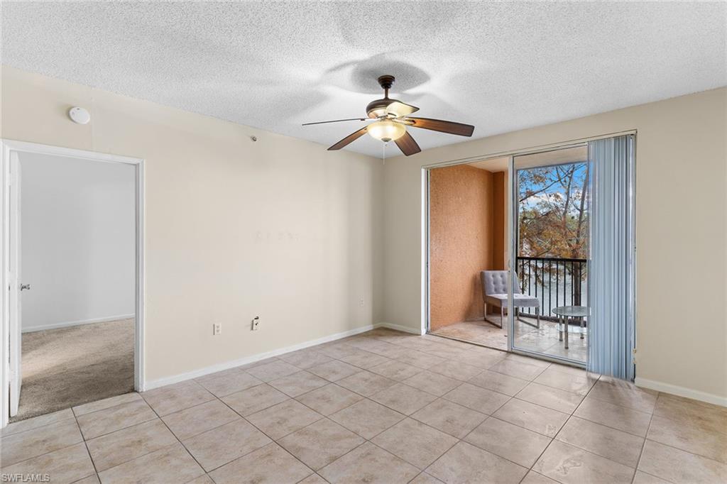 1130 Reserve Way, Unit 3 Naples, FL 34105 - Photo 3 of 25 Empty room featuring a textured ceiling, a ceiling fan, and light tile patterned flooring