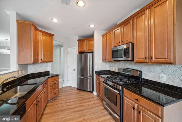 a kitchen with stainless steel appliances a stove sink microwave and cabinets
