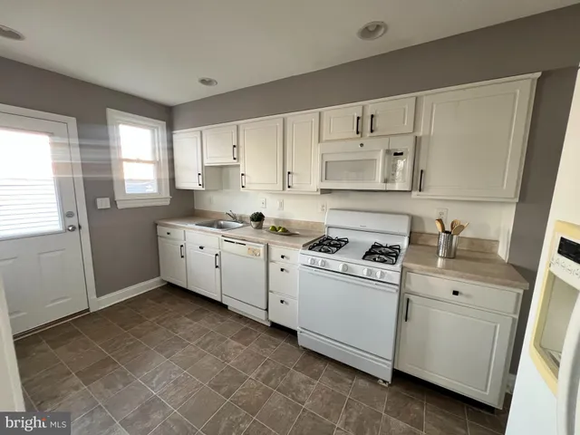 a kitchen with cabinets appliances and a window
