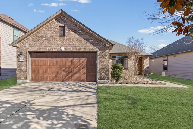 a front view of a house with a yard and garage