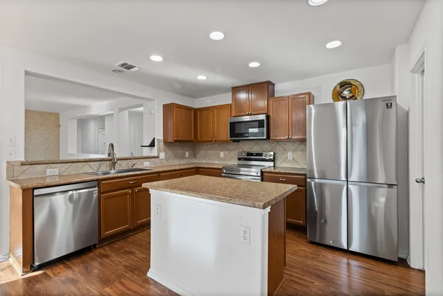 a kitchen with a refrigerator a sink and cabinets