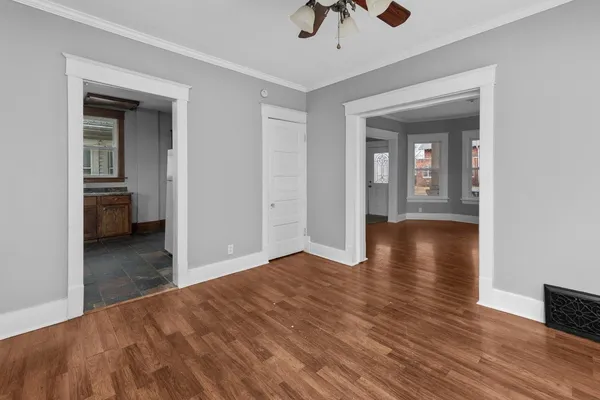 a view of a hallway with wooden floor and chandelier