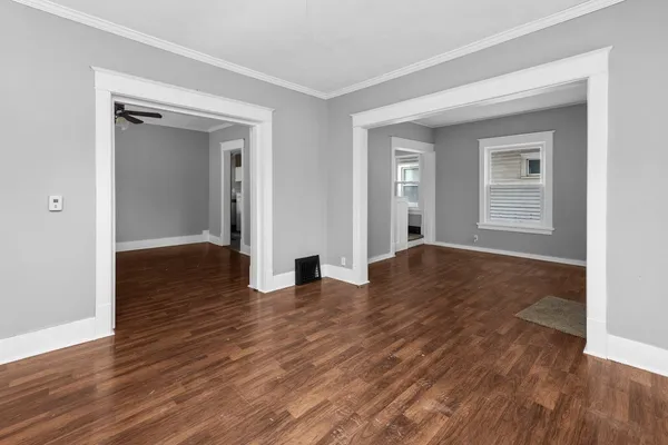 a view of empty room with wooden floor
