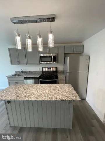 a kitchen with kitchen island a refrigerator sink and stove