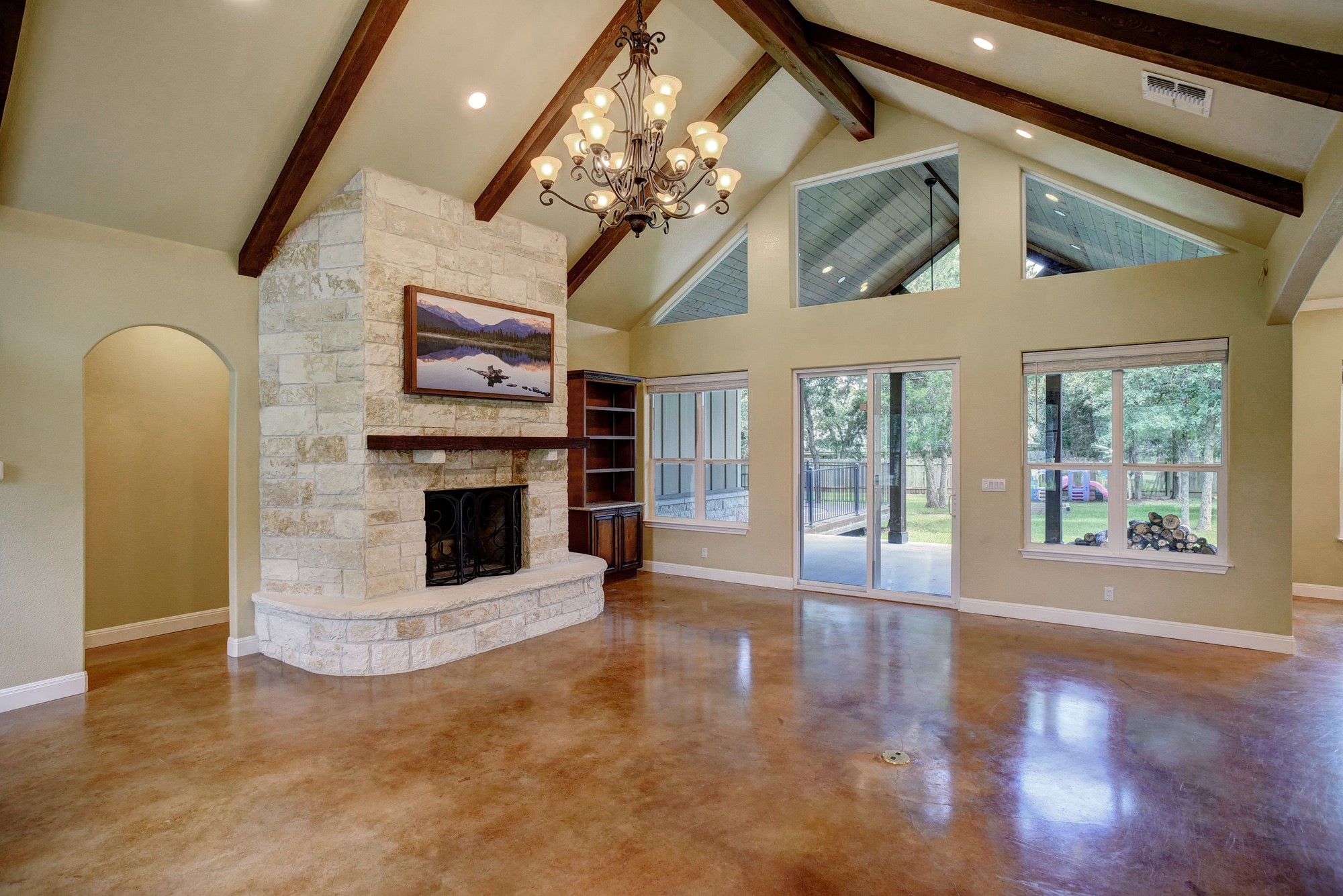 115 Pine Point Cove Elgin, TX 78621 - Photo 5 of 39 Vaulted ceilings and exposed wood beams define this elegant living space with a stately stone fireplace.