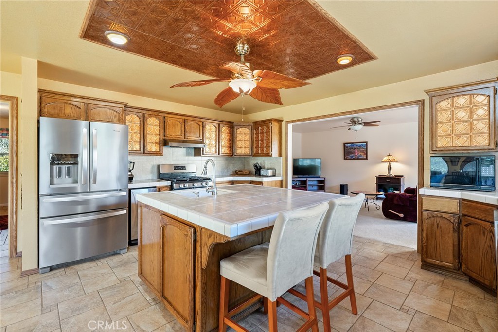 5145 Northfork Place Paso Robles, CA 93446 - Photo 21 of 62 a kitchen with stainless steel appliances granite countertop a stove a refrigerator a sink dishwasher a dining table and chairs with wooden floor