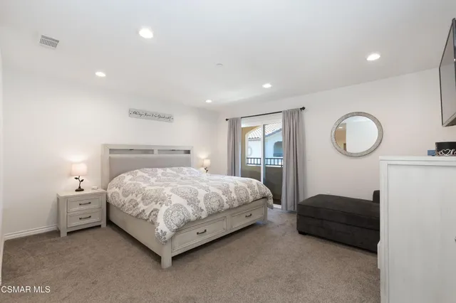 a bedroom with a bed lamp closet and a large window
