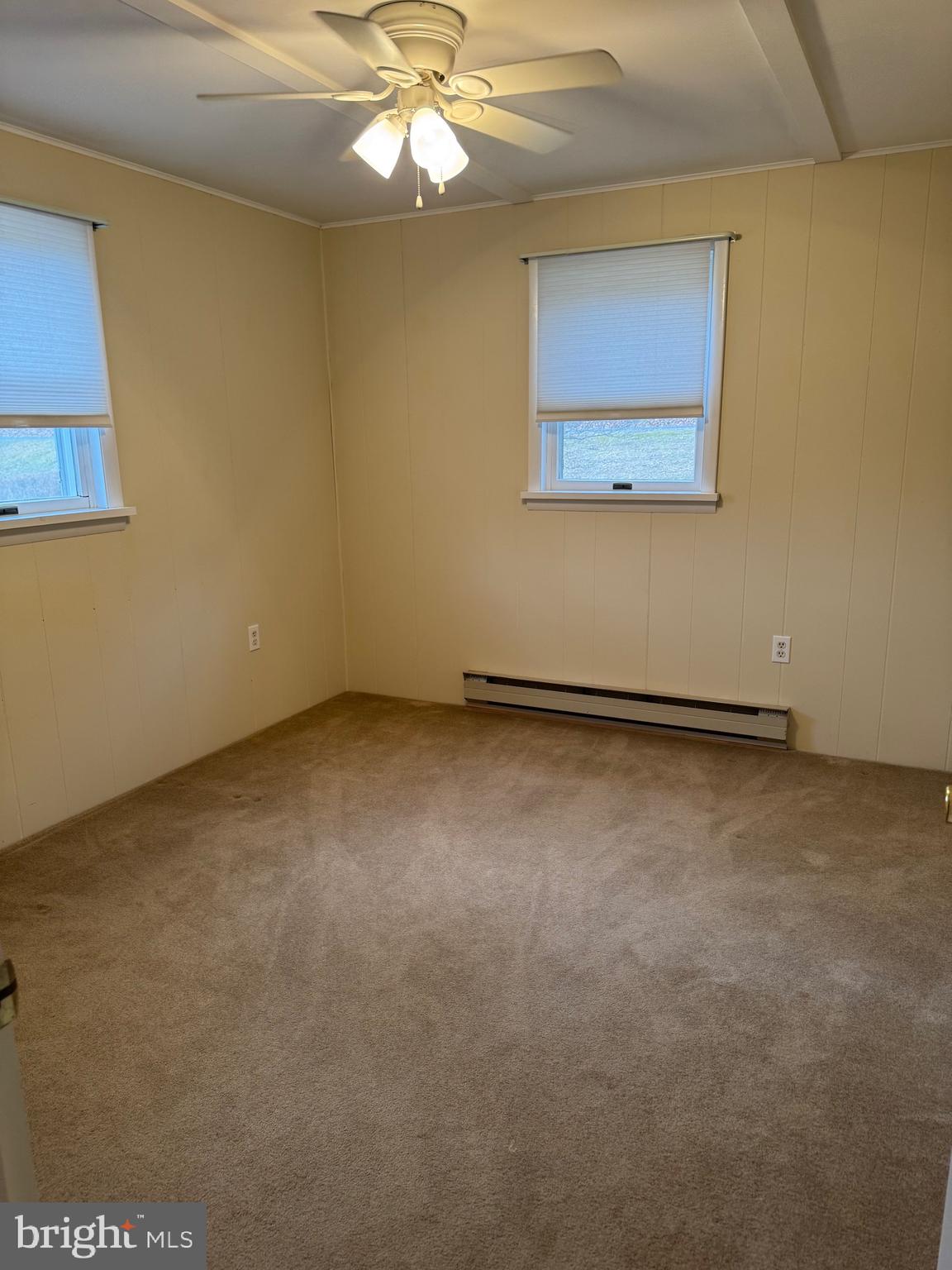 1009 Dry Wells Road Quarryville, PA 17566 - Photo 12 of 17 an empty room with a chandelier fan and windows
