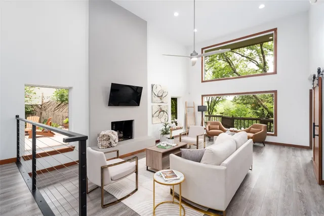 a living room with furniture a flat screen tv and a large window