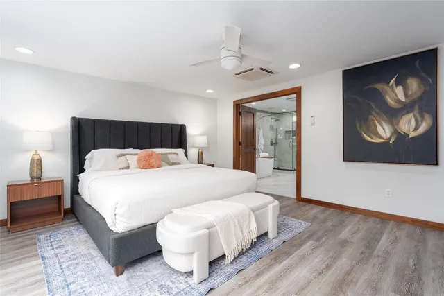 a bedroom with a large bed and a painting on the wall