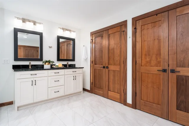 a spacious bathroom with a double vanity sink and a mirror