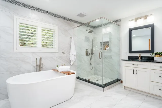 a bathroom with a tub a sink and a shower