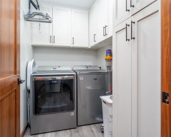 a utility room with stainless steel appliances washer and dryer