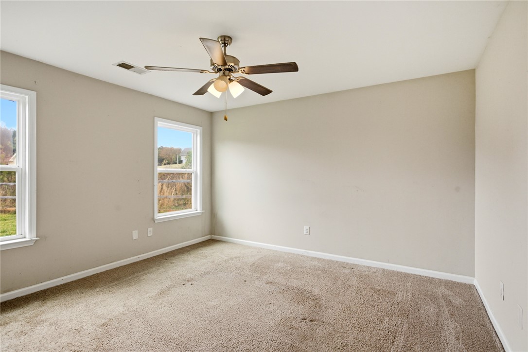 245 Maple Grove Road Seneca, SC 29678 - Photo 19 of 40 This spacious bedroom offers ample natural light and a comfortable, inviting atmosphere.