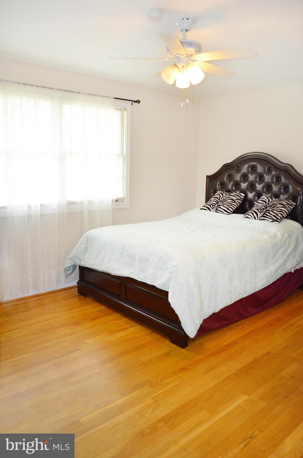 5534 Callander Drive Springfield, VA 22151 - Photo 13 of 20 a bedroom with a bed and a chandelier
