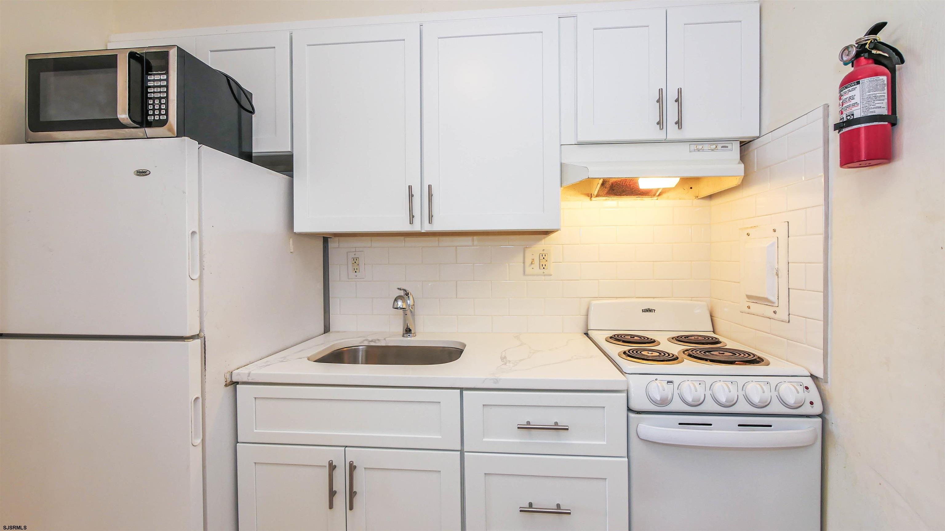 101 South Raleigh Avenue, Unit 521 Atlantic City, NJ 08401 - Photo 7 of 27 a kitchen with stainless steel appliances granite countertop a sink a stove and a refrigerator