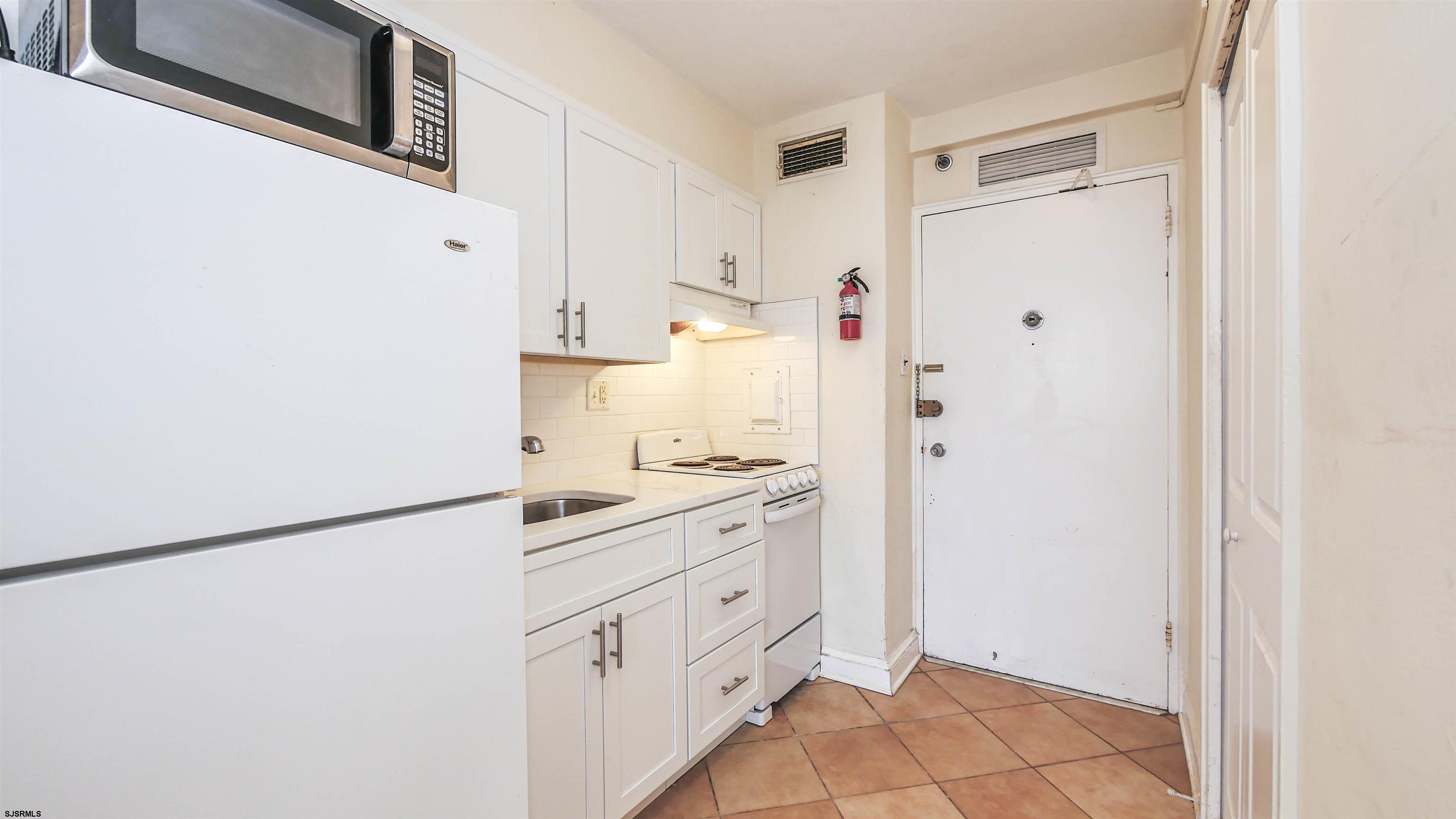 101 South Raleigh Avenue, Unit 521 Atlantic City, NJ 08401 - Photo 8 of 27 a kitchen with white cabinets and white appliances