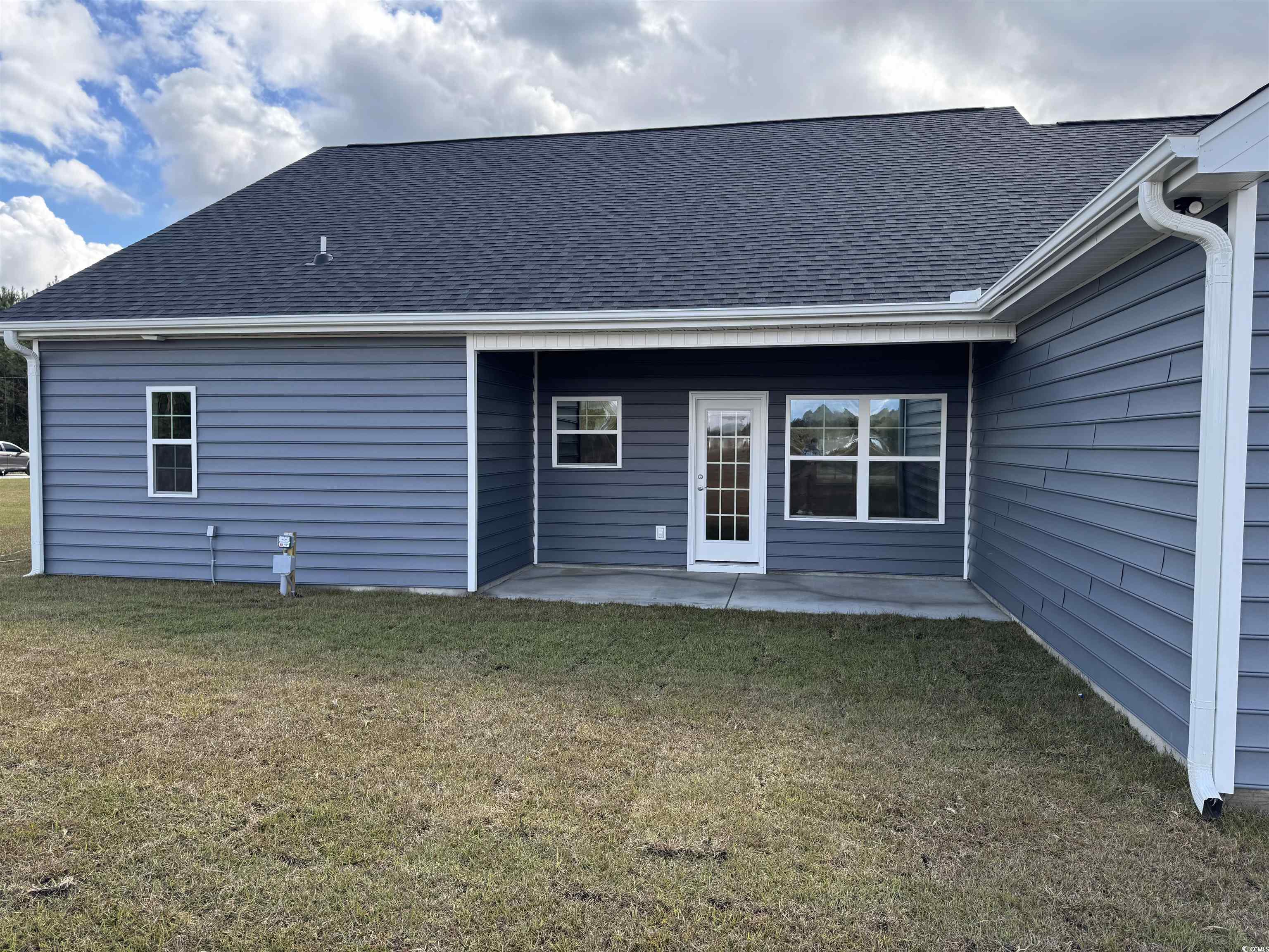 4963 Dupont Road Aynor, SC 29511 - Photo 16 of 18 Back of property with a patio, a lawn, and a shingled roof