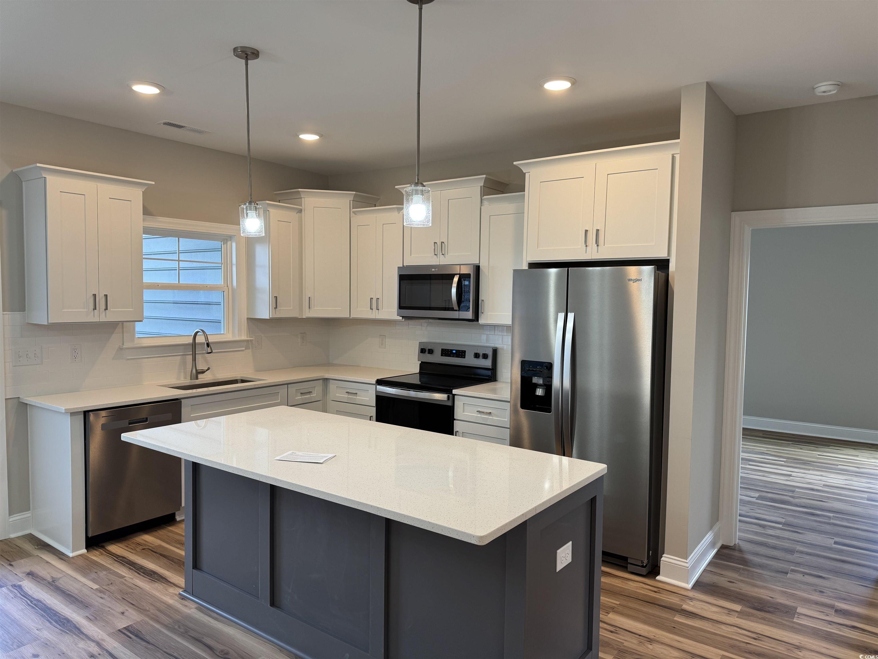4963 Dupont Road Aynor, SC 29511 - Photo 4 of 18 Kitchen with stainless steel appliances, light stone countertops, a kitchen island, white cabinets, and recessed lighting