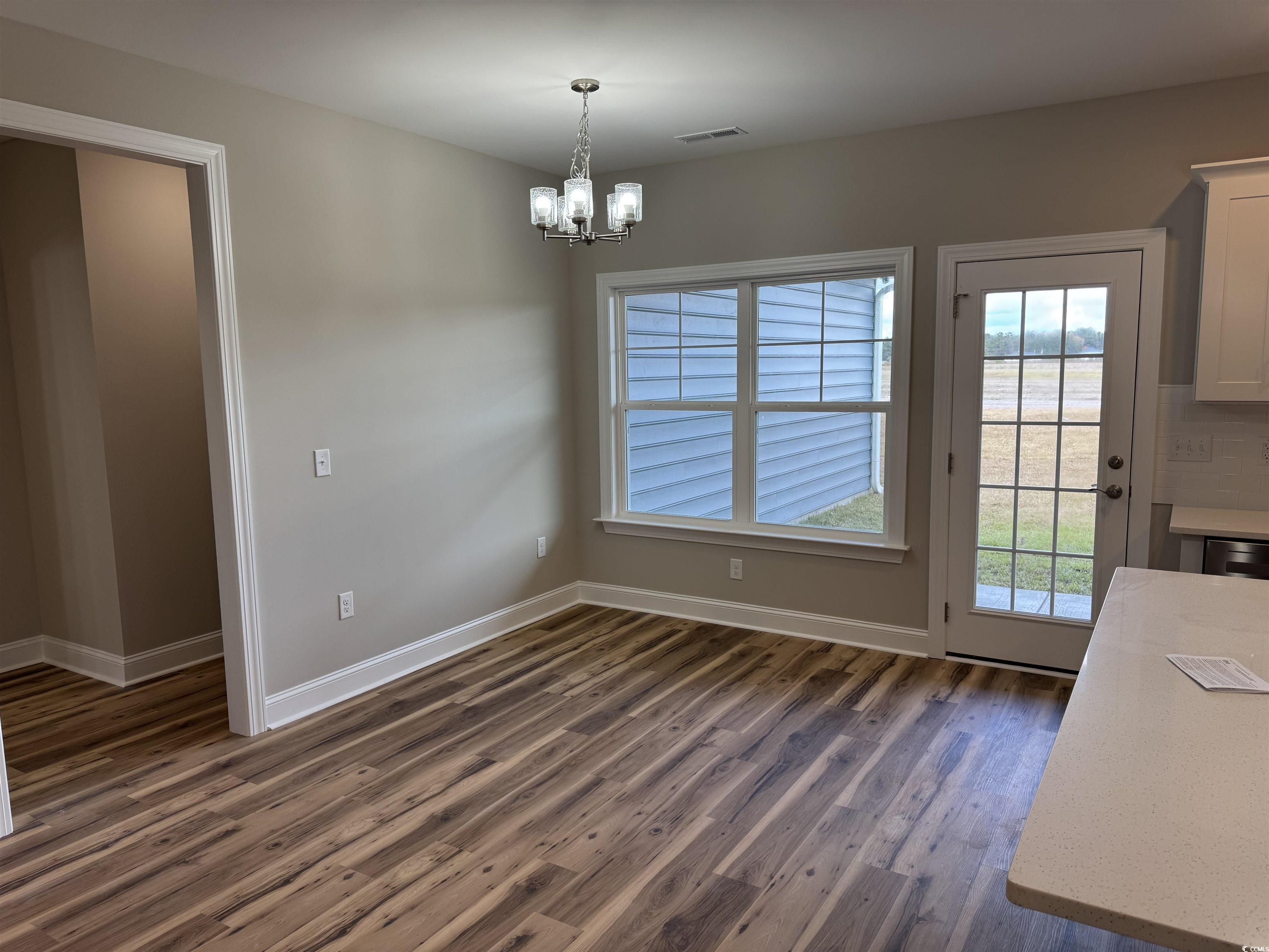 4963 Dupont Road Aynor, SC 29511 - Photo 7 of 18 Unfurnished dining area featuring plenty of natural light, dark wood finished floors, and a chandelier