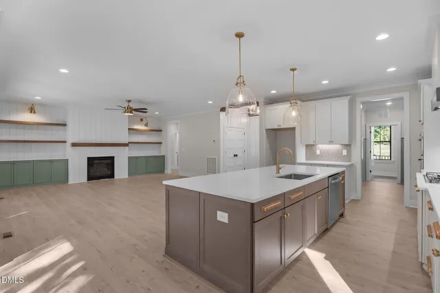 a kitchen with a sink a center island stainless steel appliances and cabinets