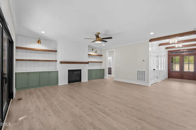 a view of an empty room with a fireplace and a window