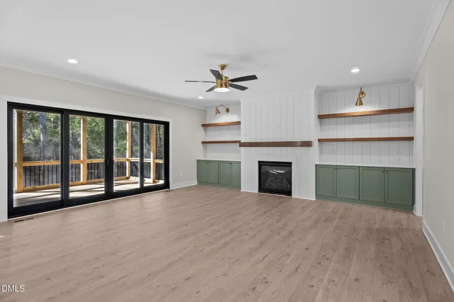 a large kitchen with granite countertop a stove a sink a center island and wooden floor