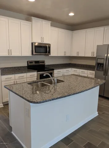 a view of kitchen with wooden floor and electronic appliances