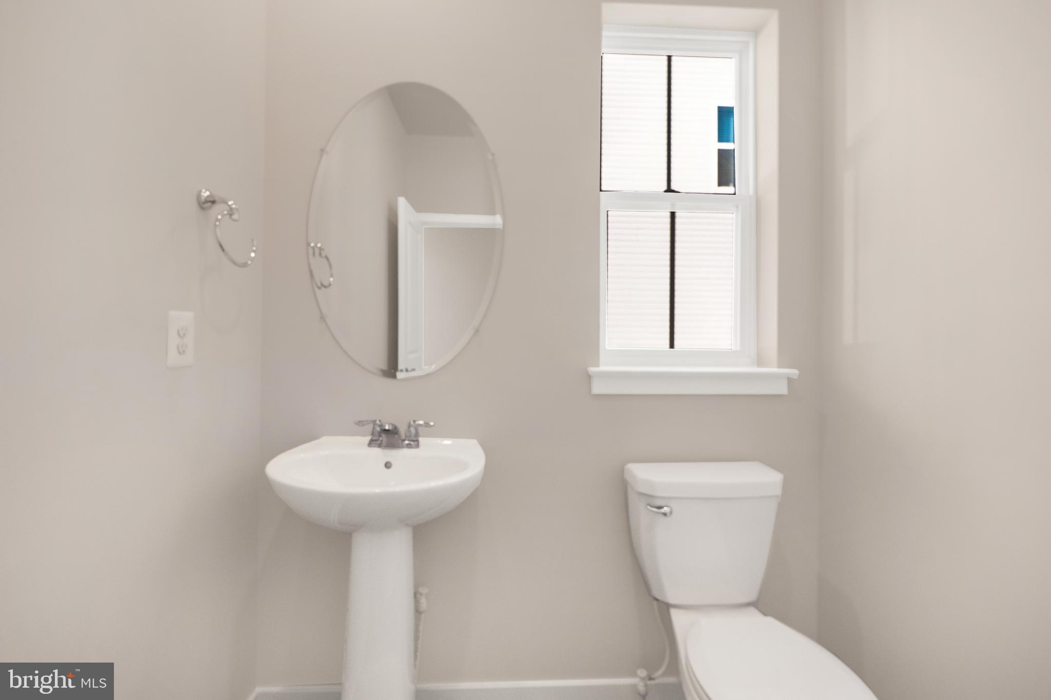 493 Mountain Laurel Boulevard Ranson, WV 25438 - Photo 7 of 27 a bathroom with a toilet sink and mirror