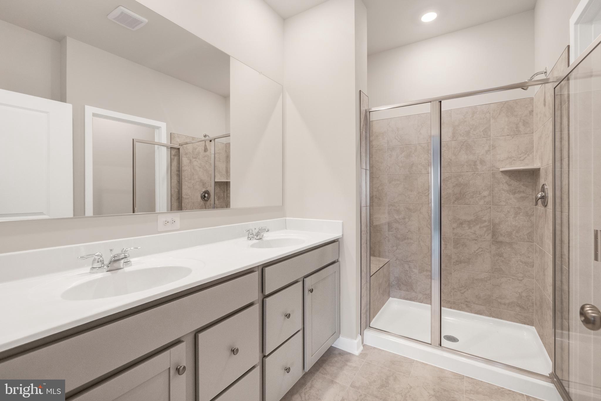 493 Mountain Laurel Boulevard Ranson, WV 25438 - Photo 10 of 27 a bathroom with a shower sink and mirror