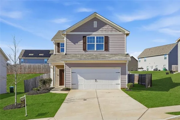 a front view of a house with a garden and yard