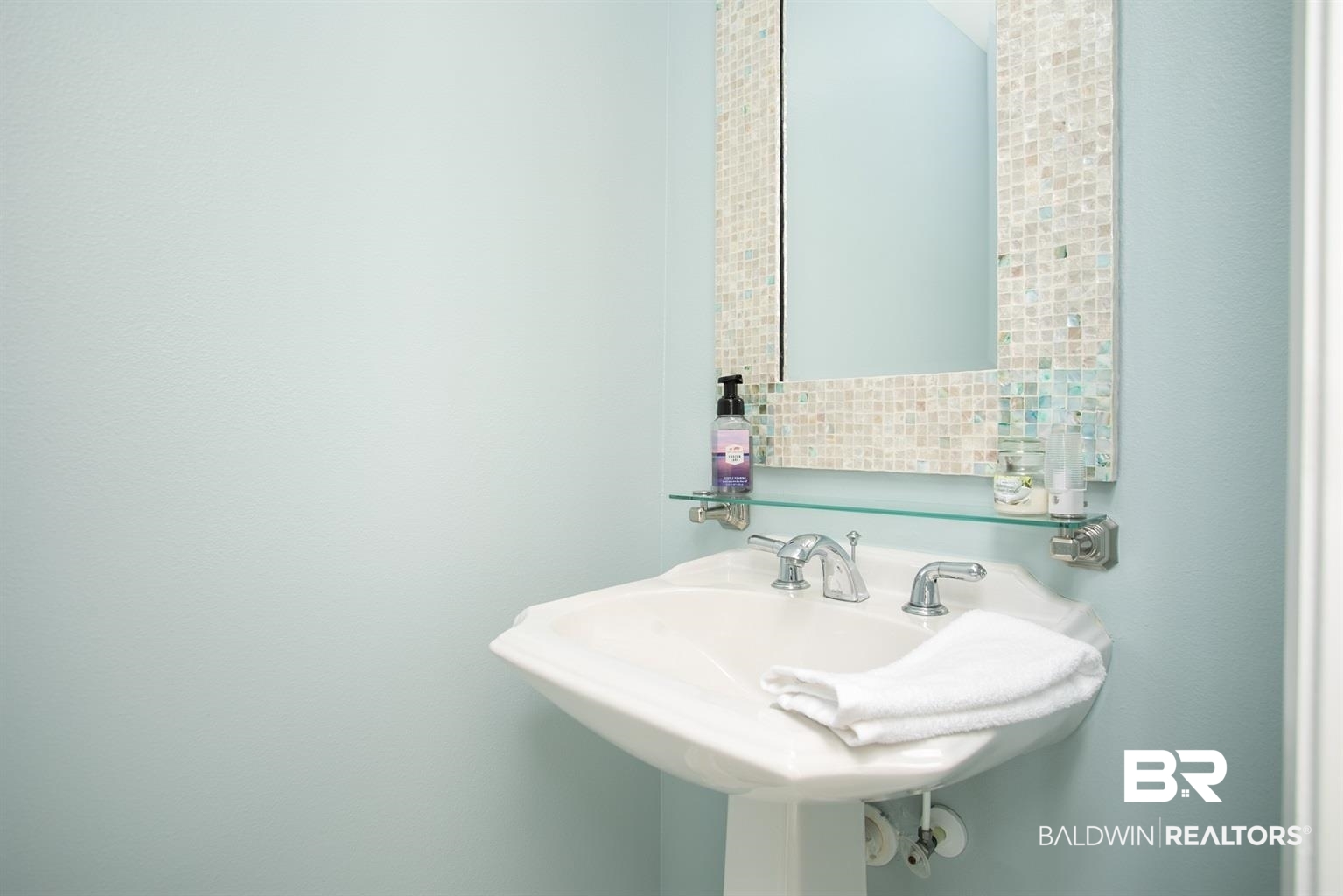 27800 Canal Road, Unit 411 Orange Beach, AL 36561 - Photo 24 of 49 Pedestal sink with chrome fixtures and a mosaic-tiled mirror frame