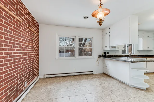 a kitchen with a chandelier fan and cabinets