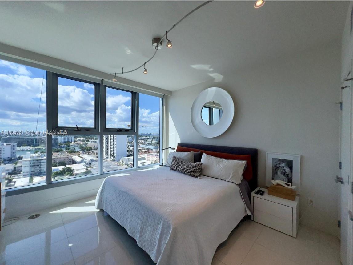 6899 Collins Avenue, Unit 1709 Miami Beach, FL 33141 - Photo 14 of 18 a bedroom with a large bed and a large window