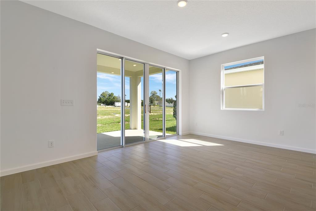 6169 Southwest 64th St Road Ocala, FL 34474 - Photo 11 of 25 a view of an empty room with wooden floor and a window