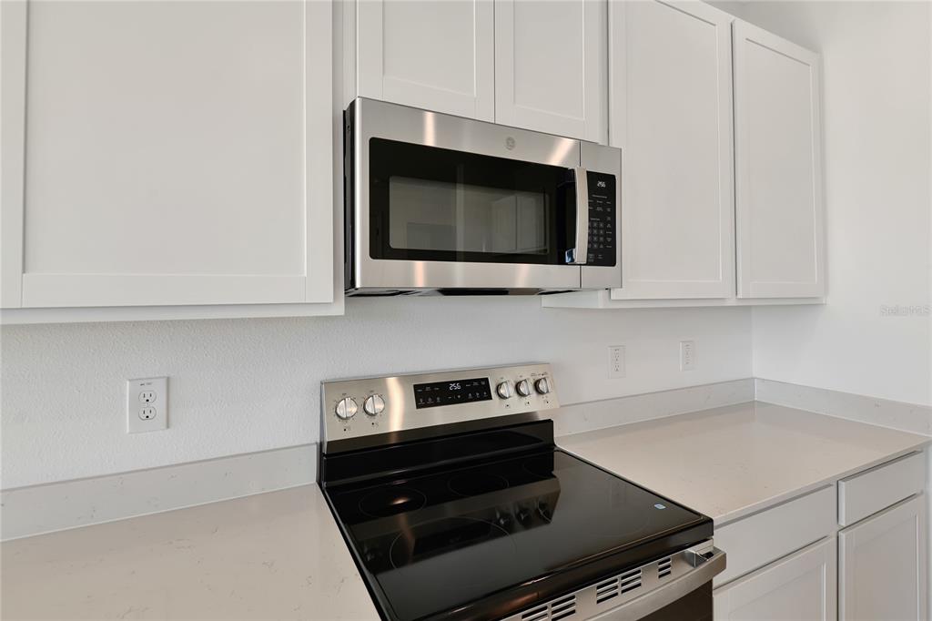 6169 Southwest 64th St Road Ocala, FL 34474 - Photo 8 of 25 a kitchen with microwave cabinets and stove top oven