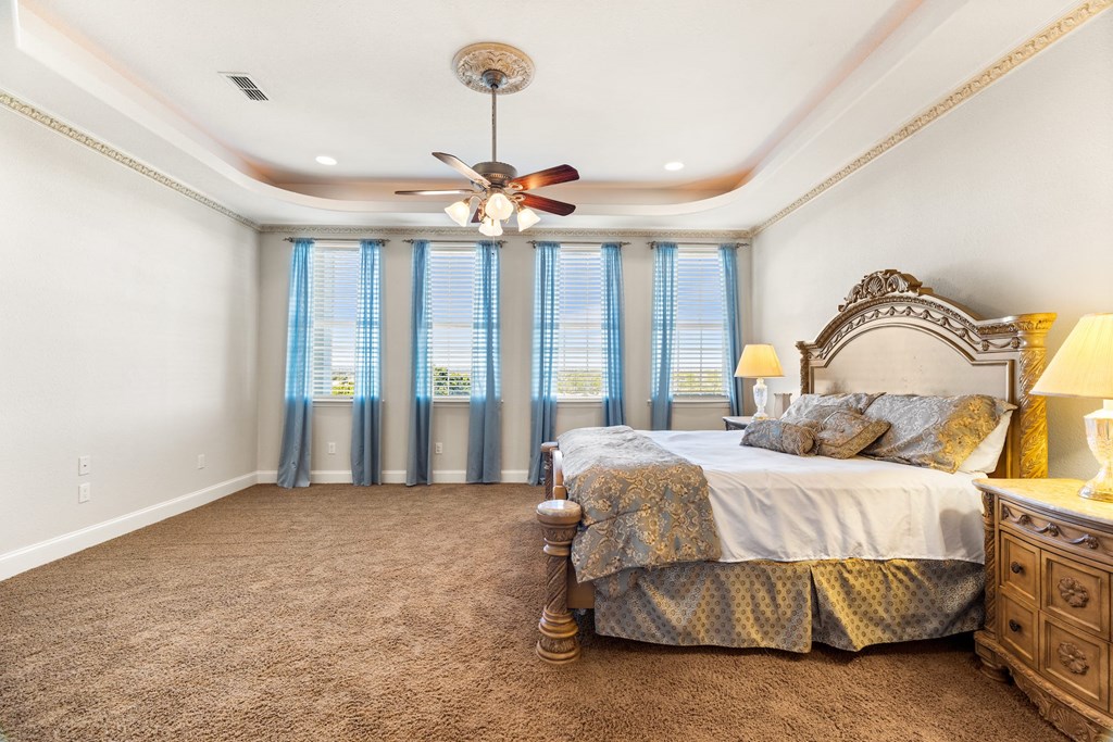 157 McCullough Ranch Road Kerrville, TX 78028 - Photo 40 of 75 a bedroom with a bed and a chandelier