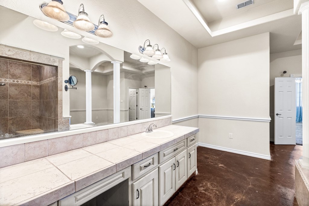 157 McCullough Ranch Road Kerrville, TX 78028 - Photo 45 of 75 a bathroom with a double vanity sink and a mirror